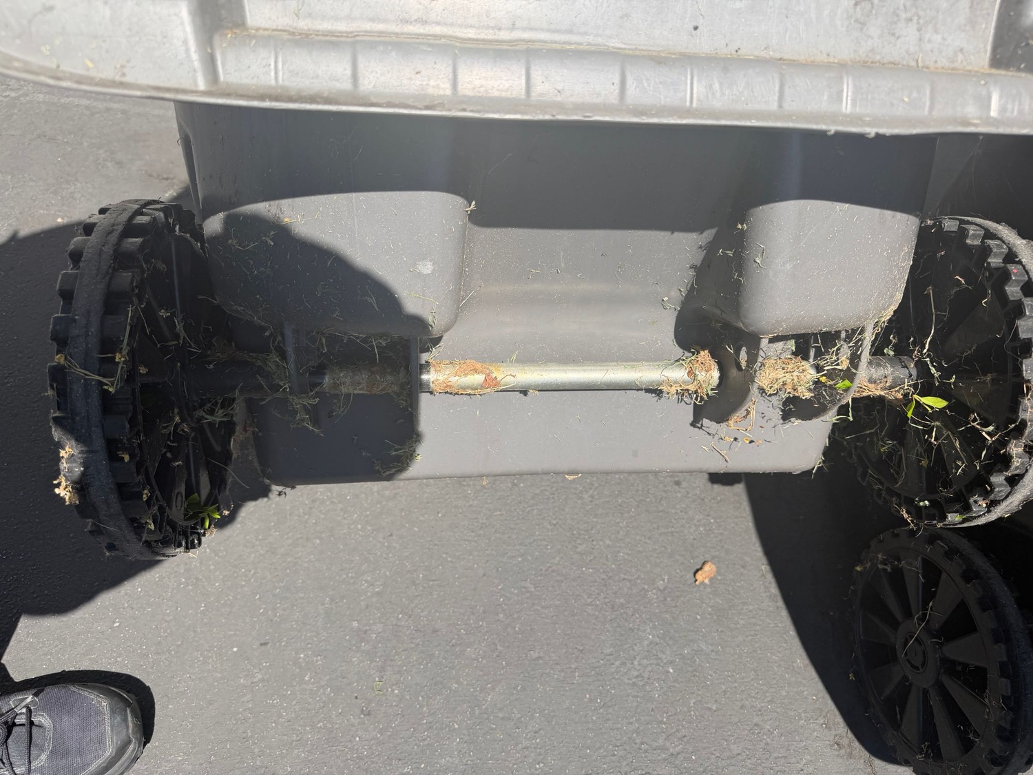 Before: trash bin wheels and axle covered in grass debris