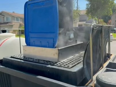 Trash bin being cleaned on the trailer blaster